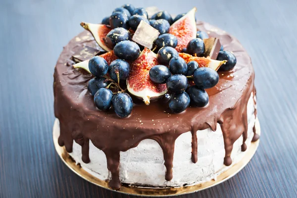 Chocolate cake with icing, decorated with fresh fruit — Stock Photo, Image