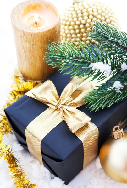 Golden Christmas composition with gift box, candle and branch of — Stock Photo, Image