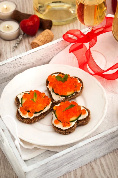 Heart shaped toasts  with red caviar and white wine — Stock Photo, Image