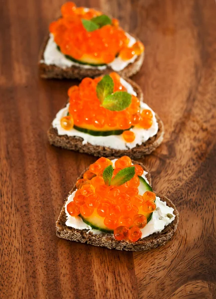 Heart shaped toasts with red caviar — Stock Photo, Image