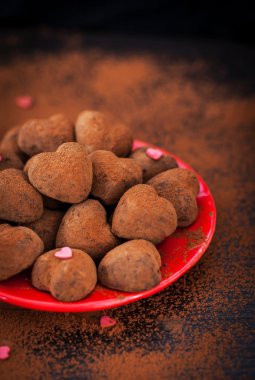 Kalp şeklinde çikolata truffles kırmızı plaka üzerinde
