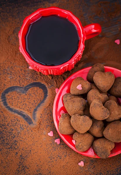 Trufas de chocolate em forma de coração e xícara de café — Fotografia de Stock