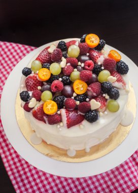 Beyaz çikolatalı kek dekore edilmiş taze meyveler ve meyve