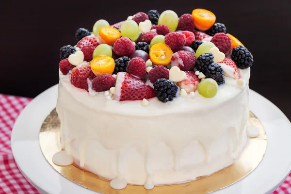 Белый шоколадный торт украшен свежими ягодами и фруктами — стоковое фото