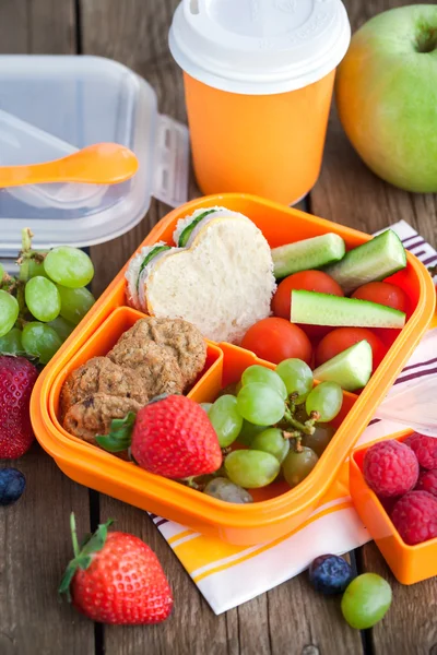 Обідня коробка з бутербродом, печивом, овочами та фруктами — стокове фото