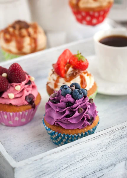 Different delicious cupcakes and coffee cup — Stock Photo, Image