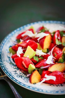 Taze bahar salatası. Avokado, domates, şeftali, kırmızı soğan ve bitkiler.