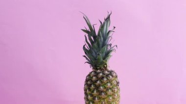 Pembe temada yavaş dönen yarım ananas