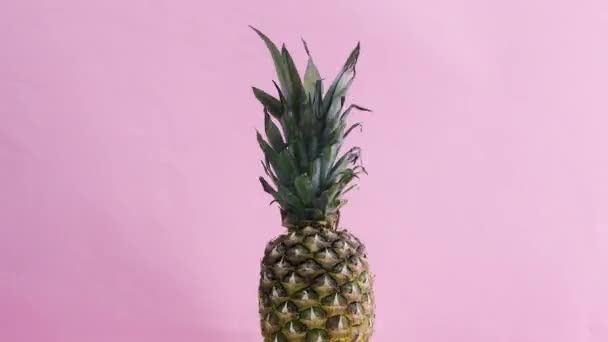 Schnelles Und Langsames Drehen Der Halben Ananas Auf Rosa Thema — Stockvideo