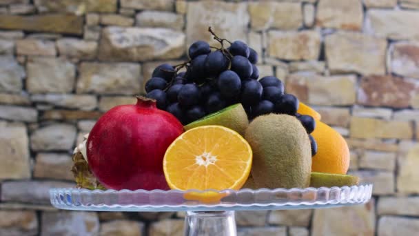グラスクリスタルボウルに様々な種類の新鮮な熟した果物をゆっくりと回転させる — ストック動画