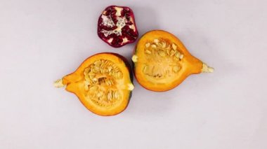 Gümüş temada dilimlenmiş balkabağı, hindistan cevizi, nar, limon ve portakallar görünür. Hareketi durdur 