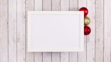 Altın ve kırmızı Noel süsleri boş çerçeve etrafında yazılı olarak belirir. Hareketi durdur 