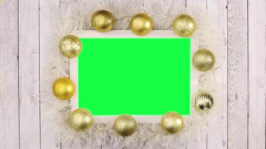 Altın topları, yanıp sönen ışıkları ve yeşil ekranı olan altın bir Noel çerçevesi. Hareketi durdur