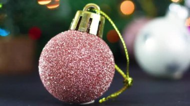 Pembe pastel, altın rengi Noel ağacı süsü ve yanıp sönen ışıklar.