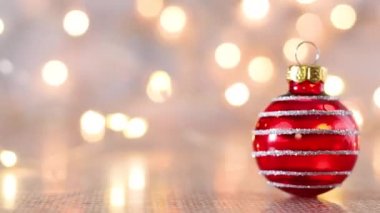 Arkasında yanıp sönen ışıklar olan kırmızı, şirin bir Noel süsü. Mutlu Noeller.