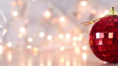 Kırmızı, parlak disko topu Noel süsü ve arkasında yanıp sönen ışıklar.