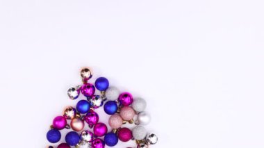 Beyaz temalı Noel ağacı yapan renkli Noel süsleri. Hareketi durdur