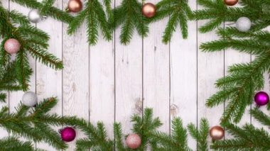 Çam dalları pembe ve gümüş süslemeler ve yanıp sönen ışıklarla çerçeve yapıyorlar. Hareketi durdur