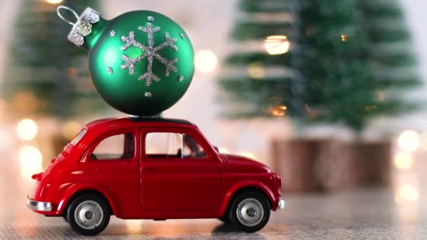 Pequeño Coche Rojo Con Adorno Navidad Verde Techo — Vídeos de Stock