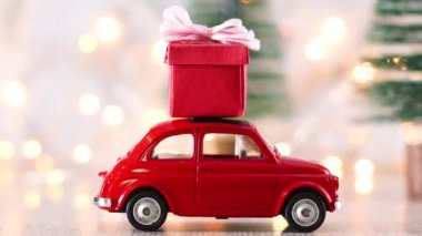 Yanıp sönen ışıklar ve çatıda kırmızı Noel süsü olan küçük kırmızı bir araba.