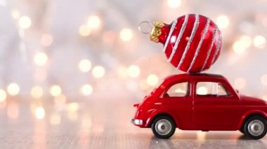 Çatıda küçük kırmızı Noel süsü olan küçük bir Noel arabası. 