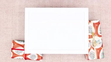 Noel hediyeleri ve çam dalları çerçeve etrafında metin olarak görünür. Hareketi durdur