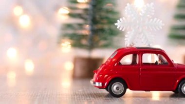 Çatıda kar taneleri ve yanıp sönen ışıklar olan bir Noel arabası.