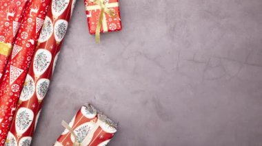 Noel ambalaj kağıtları, hediyeler, süsler ve çam dalları sol tarafta görünür. Hareketi durdur