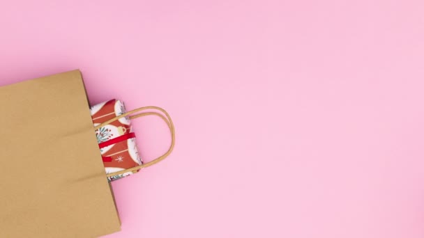 有彩带的圣诞礼物出现在购物袋里 主题是粉红的面糊 停止运动 — 图库视频影像