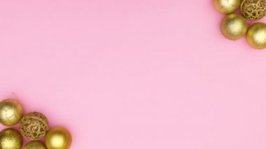 Pastel pembe temanın sol ve sağ köşesinde altın parıltılı Noel süsleri görünür. Hareketi durdur