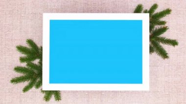 Mavi ekranlı çerçeve ve pembe süslemeli çam dalları. Hareketi durdur