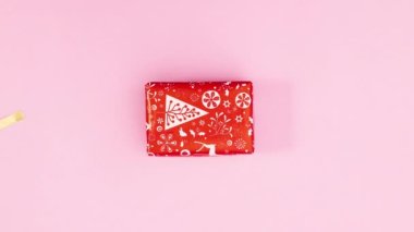 Pembe temalı Noel hediyesi üzerine altın kurdele. Hareketi durdur
