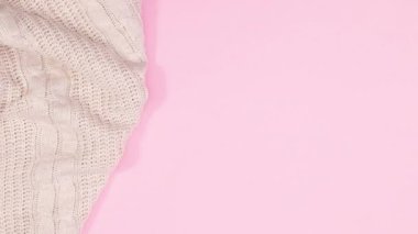 Pastel pembe temalı süveter Noel süsleriyle birlikte görünür.