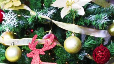 Altın, kırmızı süsler ve yanıp sönen ışıklarla güzel bir Noel ağacı.