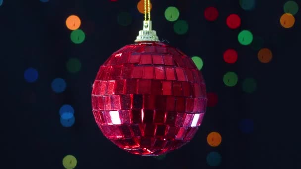 赤いガラスのクリスマスの飾りの背後に点滅する光でスイング — ストック動画