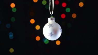 Parlayan yıldızlı beyaz Noel süsü yanıp sönen ışıklarla sallanıyor.