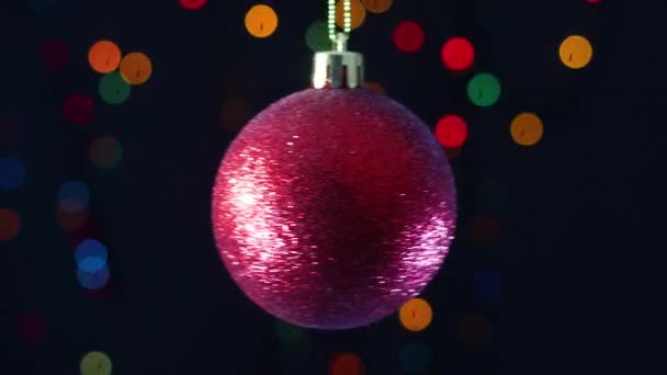赤い輝きのクリスマスの飾りの背後に点滅する光でスイング — ストック動画
