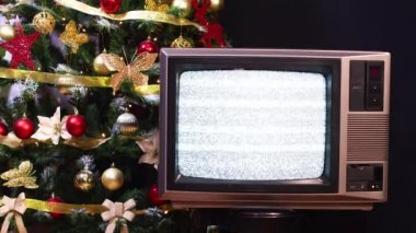 Vintage televizyon çalışmıyor ve arkasında yanıp sönen ışıklar olan Noel ağacı.