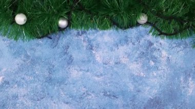 Üzerinde gümüş süsler ve yanıp sönen ışıklar olan Noel çelengi. Hareketi durdur