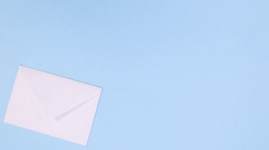 Sevgililer Günü için kırmızı çiçekler ve kalplerle mavi temalı zarftan kağıt çıkar. Hareketi durdur