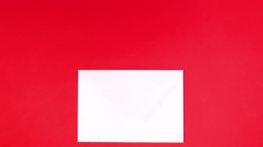 Kırmızı temalı beyaz zarftan küçük kalpler çıkıyor. Hareketi durdur