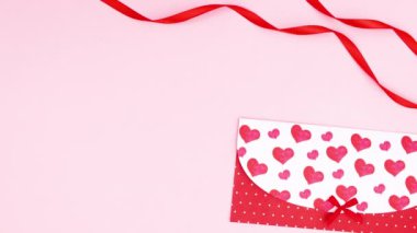 Sevgililer günü hediyesi zarf ve kurdelelerin yanında daire çiziyor. Hareketi durdur