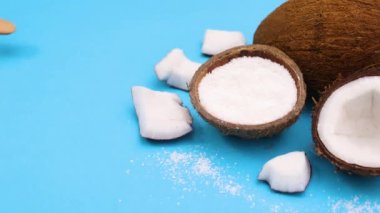 Mavi temalı tahta kaşıkla hindistan cevizi tozu almak. Hareketi durdur