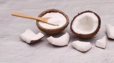 Dilimlenmiş hindistan cevizi ve tahta kaşıkla hindistan cevizi tozu. Hareketi durdur