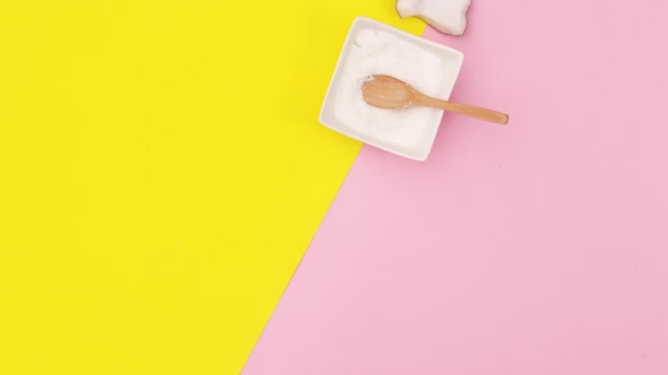 黄色とピンクのテーマの間にスライスされ 半分のココナッツとパウダーココナッツが並んで表示されます 動くな — ストック動画