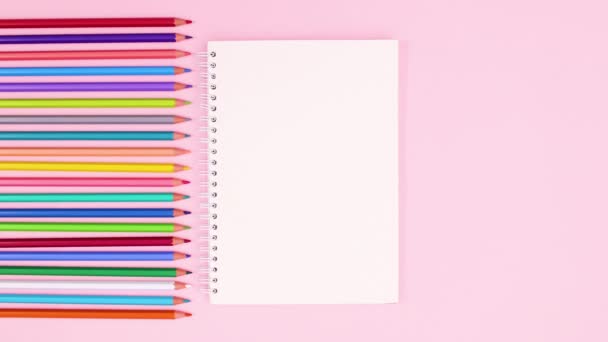 Open Notebook Verschijnen Naast Pastel Gekleurde Potloden Stop Met Bewegen — Stockvideo