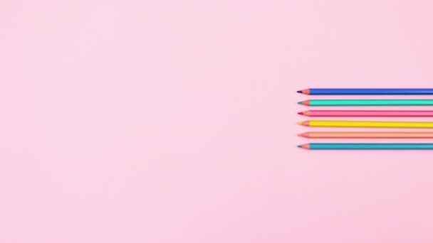 異なる色の鉛筆は パステルピンクのテーマの右側に表示されます 動くな — ストック動画
