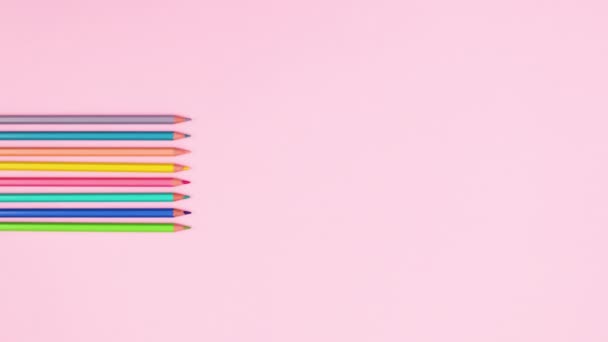 不同颜色的铅笔出现在粉红粉红主题的左边 停止运动 — 图库视频影像