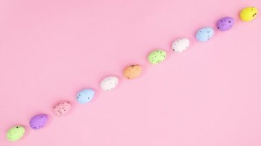 Paskalya renkli yumurtalar pastel pembe temada sırada belirir. Hareketi durdur