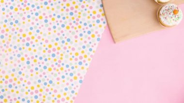 Kesme tahtasının üzerinde kremalı kekler var ve biri de tabakta geliyor. Hareketi durdur